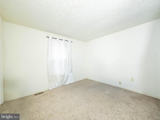 carpeted spare room with a textured ceiling