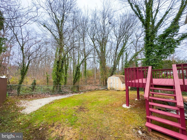 view of yard featuring a storage unit and a wooden deck