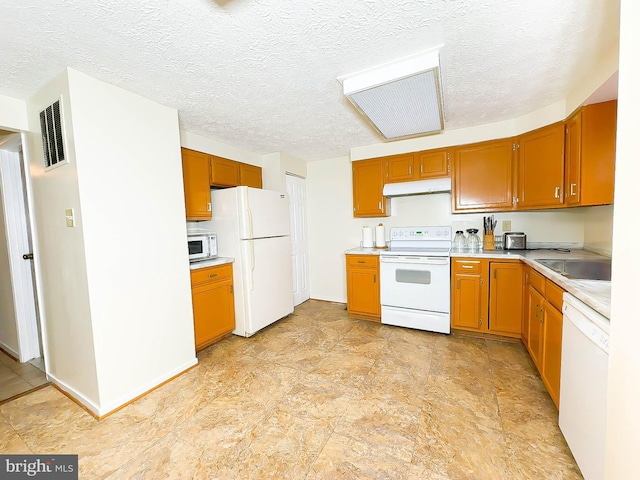 kitchen featuring a textured ceiling, sink, and white appliances