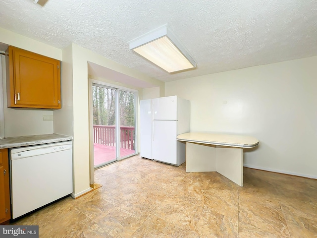 kitchen featuring a textured ceiling and white appliances