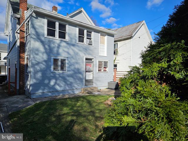 rear view of property with a yard and central AC