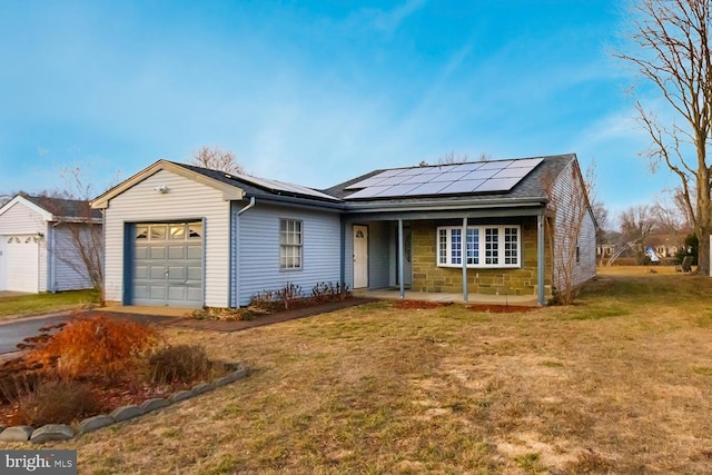 single story home with a garage, a front yard, and solar panels