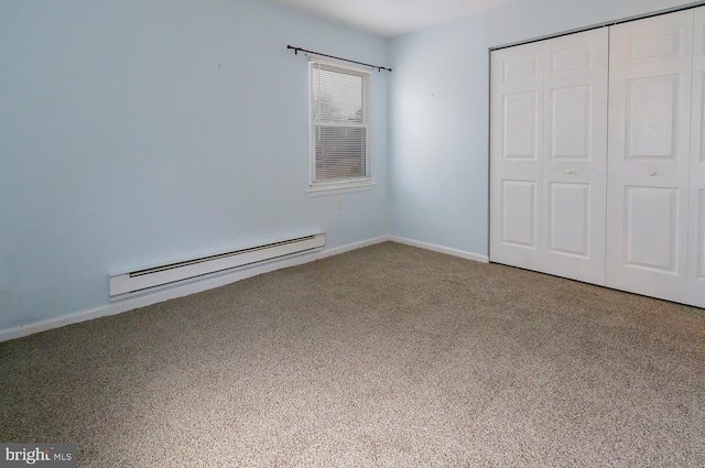 unfurnished bedroom featuring a baseboard radiator, carpet flooring, and a closet