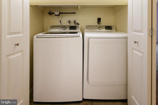 clothes washing area with washer and clothes dryer