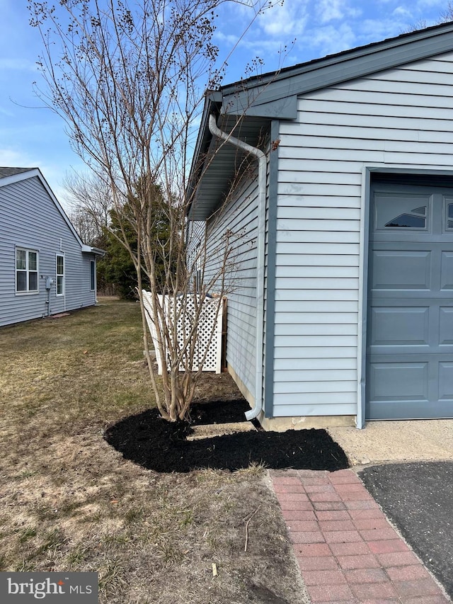 view of side of property featuring a garage and a yard