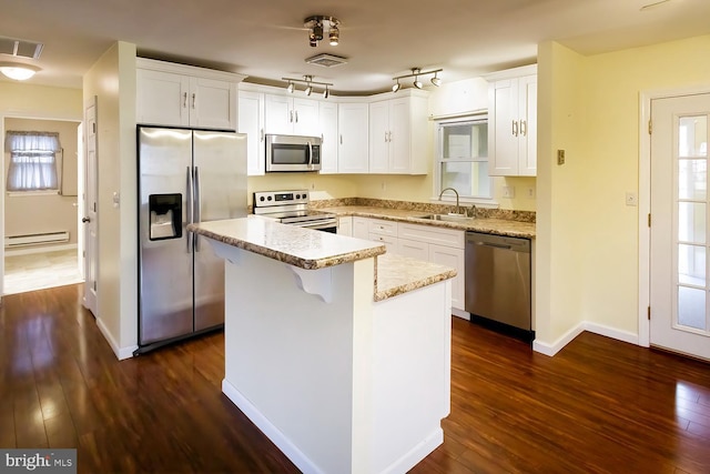 kitchen featuring sink, a center island, appliances with stainless steel finishes, dark hardwood / wood-style flooring, and white cabinets