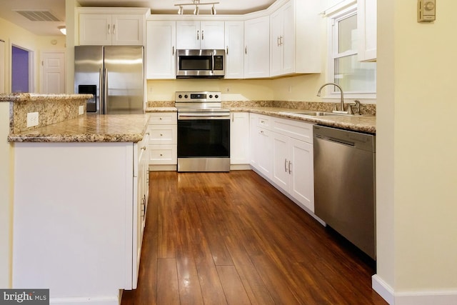 kitchen with white cabinetry, stainless steel appliances, sink, and light stone counters