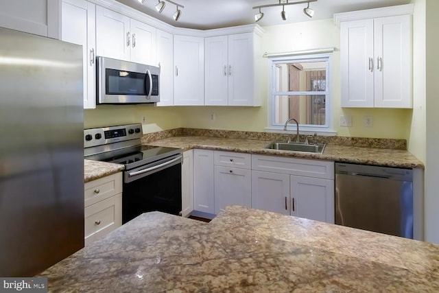 kitchen with white cabinetry, sink, stainless steel appliances, and rail lighting