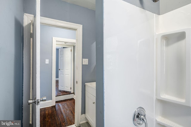 bathroom with hardwood / wood-style flooring, vanity, and walk in shower