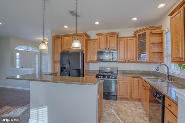 kitchen featuring black appliances, plenty of natural light, sink, and hanging light fixtures