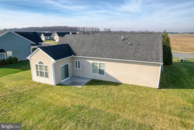 back of house with a patio and a lawn