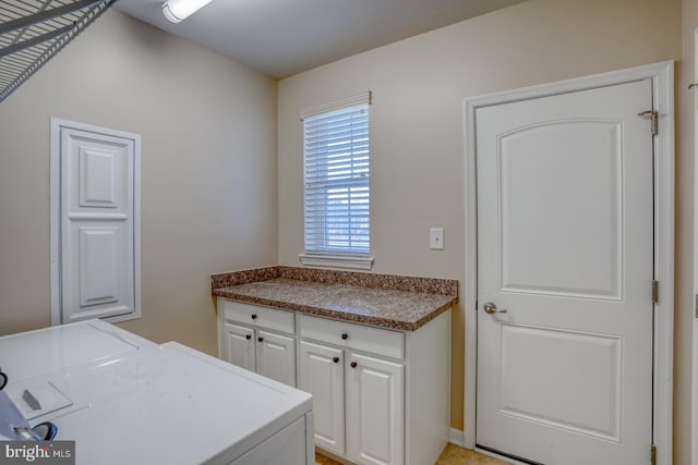 washroom with cabinets and washer and dryer