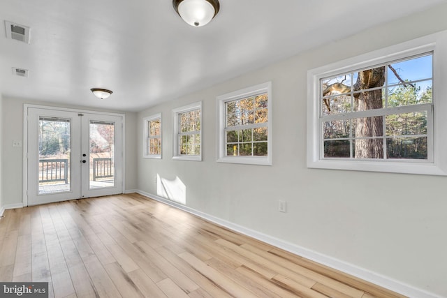 interior space featuring light wood-type flooring, a wealth of natural light, and french doors