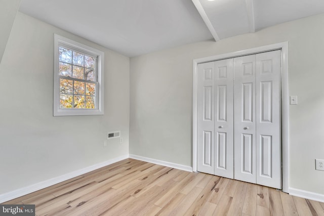 unfurnished bedroom featuring light hardwood / wood-style floors and a closet