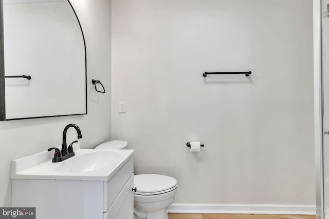 bathroom featuring vanity, wood-type flooring, and toilet