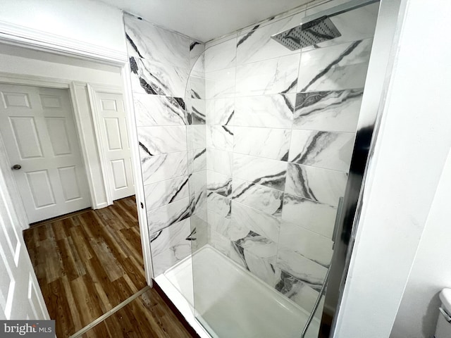 bathroom featuring hardwood / wood-style flooring and tiled shower