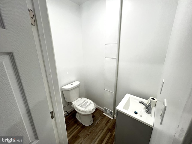 bathroom featuring wood-type flooring, vanity, and toilet