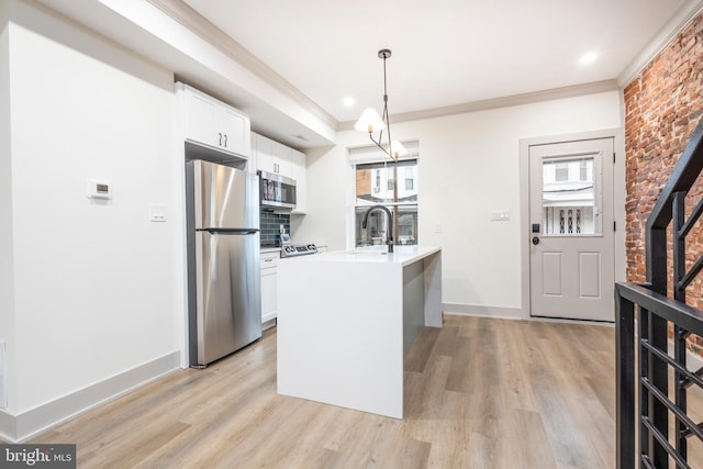 kitchen featuring white cabinetry, light hardwood / wood-style floors, decorative light fixtures, and appliances with stainless steel finishes