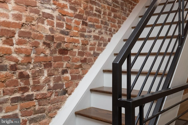 stairs featuring brick wall