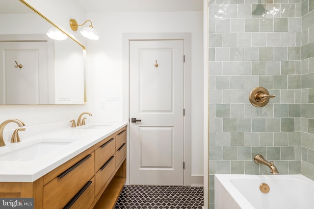 bathroom featuring tile patterned flooring, vanity, and tiled shower / bath combo