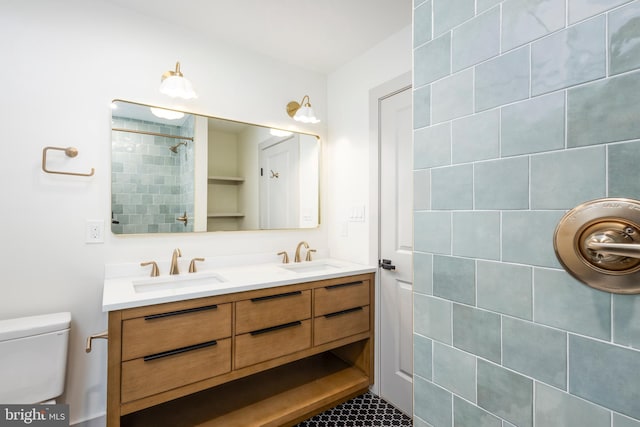 bathroom featuring vanity, toilet, and a tile shower