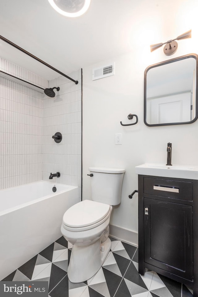 full bathroom with tiled shower / bath, vanity, and toilet