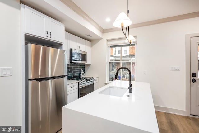 kitchen featuring a center island with sink, sink, appliances with stainless steel finishes, and tasteful backsplash