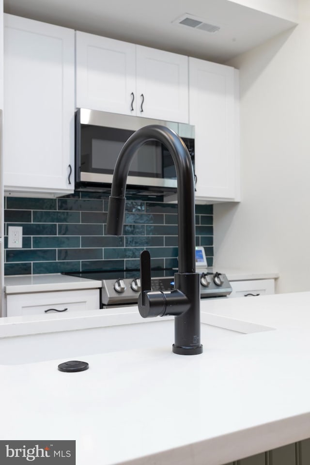 room details featuring white cabinetry and backsplash