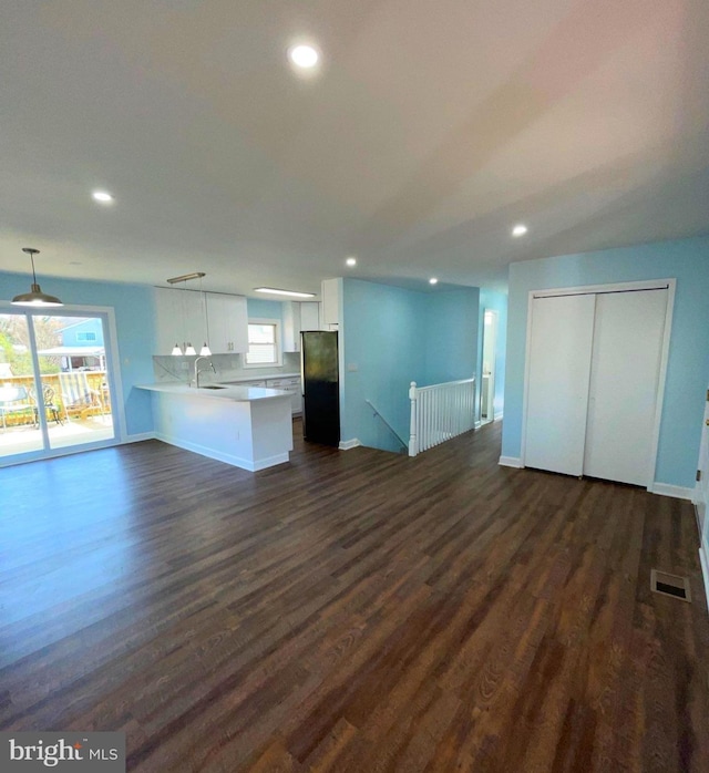 unfurnished living room featuring dark hardwood / wood-style floors and sink