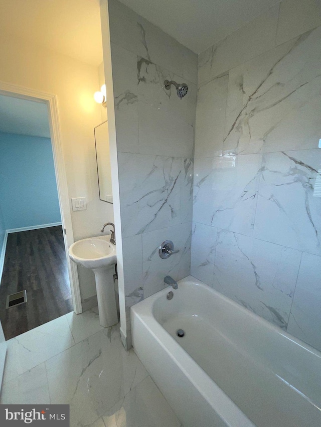 bathroom with tiled shower / bath combo and hardwood / wood-style flooring