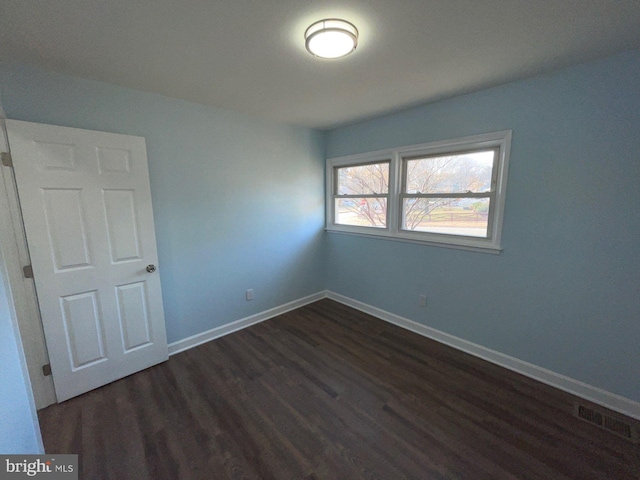 unfurnished room featuring dark hardwood / wood-style flooring