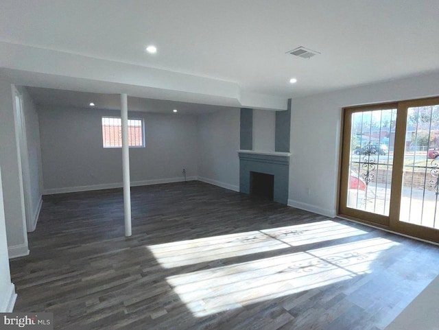 basement with dark hardwood / wood-style floors and plenty of natural light