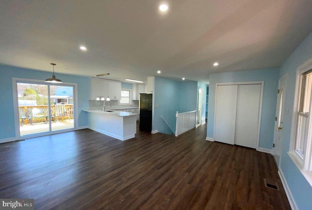 unfurnished living room with dark hardwood / wood-style floors and sink