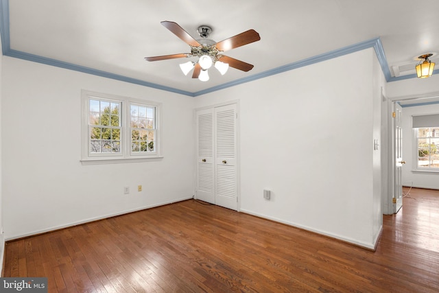 unfurnished bedroom with hardwood / wood-style floors, a closet, and ornamental molding