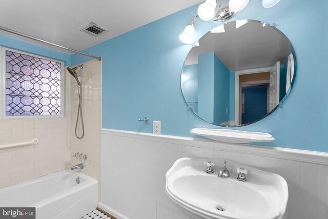 full bathroom featuring a sink, shower / bathing tub combination, visible vents, and wainscoting