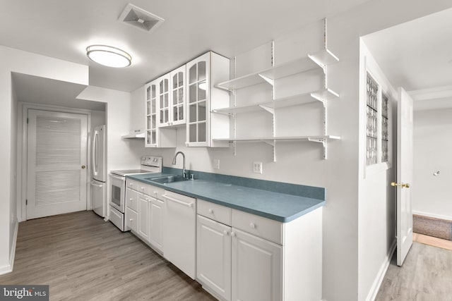 kitchen with white appliances, visible vents, open shelves, and a sink