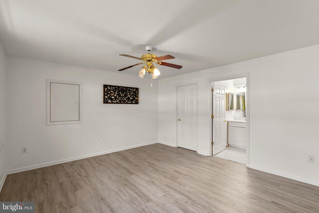 unfurnished bedroom with light wood finished floors, connected bathroom, baseboards, and ceiling fan