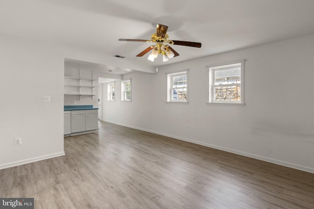 unfurnished living room with visible vents, baseboards, ceiling fan, and light wood finished floors