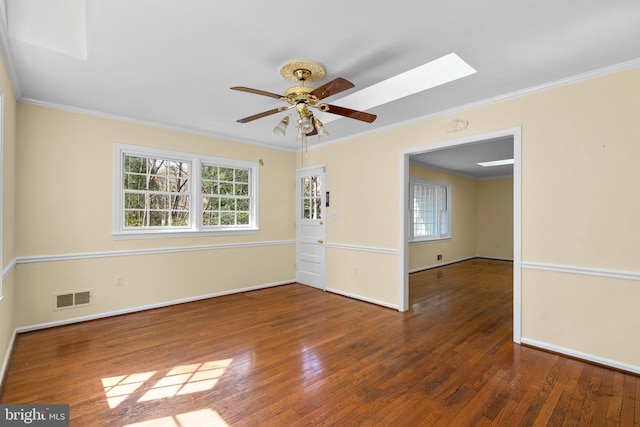 unfurnished room featuring visible vents, hardwood / wood-style floors, crown molding, baseboards, and ceiling fan