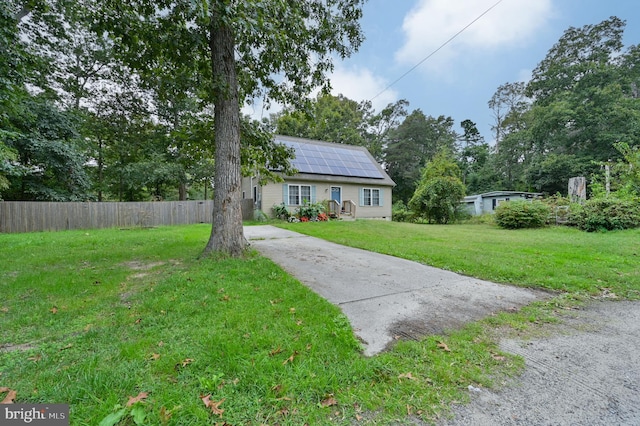 view of front of property with solar panels and a front lawn