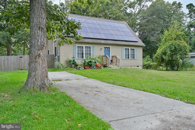 view of front of property with solar panels and a front yard