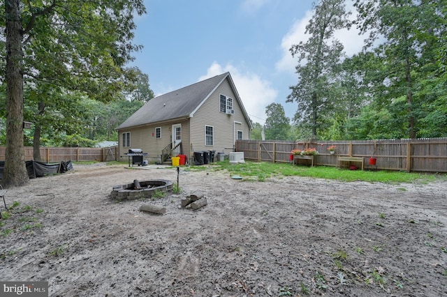 rear view of house with an outdoor fire pit