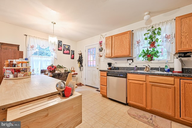 kitchen featuring sink, stainless steel dishwasher, and decorative light fixtures