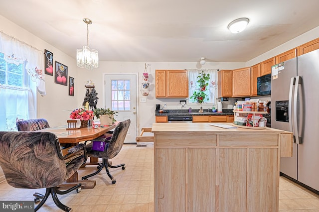 kitchen featuring a chandelier, light brown cabinetry, stainless steel appliances, and a kitchen island