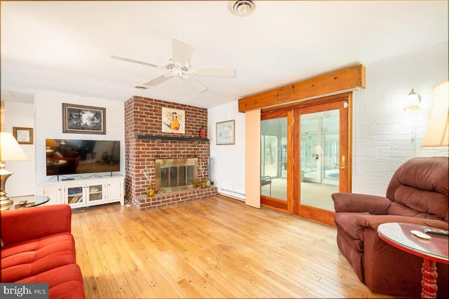 living room featuring a fireplace, light wood-type flooring, and ceiling fan