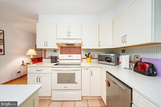 kitchen with white cabinets, appliances with stainless steel finishes, tasteful backsplash, and light tile patterned floors