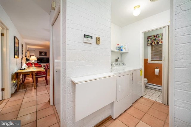 washroom featuring washer and clothes dryer, light tile patterned floors, and a baseboard heating unit