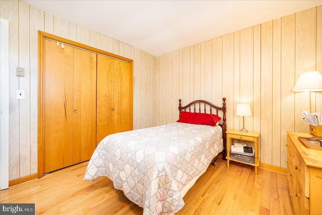 bedroom featuring a closet, hardwood / wood-style floors, and wood walls