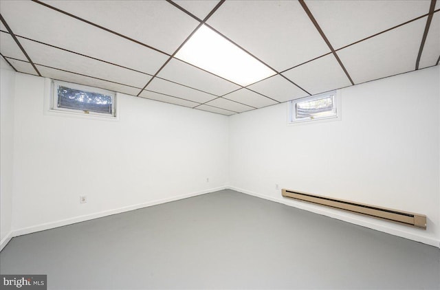 basement with baseboard heating and a drop ceiling