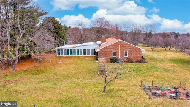 exterior space featuring a yard and a sunroom